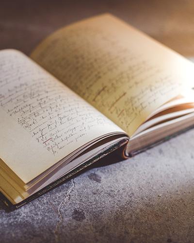 Cahier ouvert sur une table avec écriture manuscrite